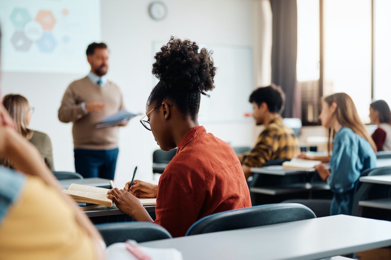 Black Female Student Taking Notes During A Class In Lecture Hall .jpg